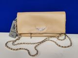 a beige clutch bag with a chain strap on a white table