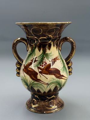 un vase orné d'un motif de cerf, posé sur une table