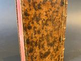 an old book sitting on top of a table next to a gray background
