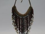 beaded necklace on a stand on a white background
