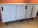 une armoire blanche à tiroirs, avec une chaise devant