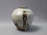 a white and brown vase sitting on a table