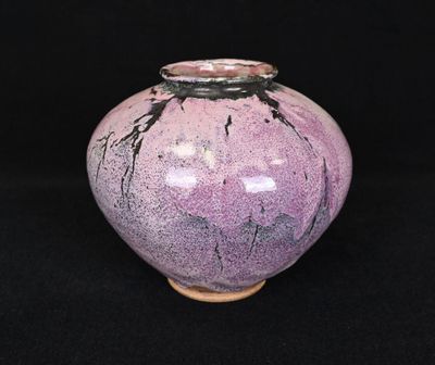 un vase violet posé sur une surface noire