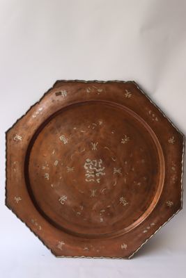 une plaque de cuivre ancienne ornée d'un motif floral