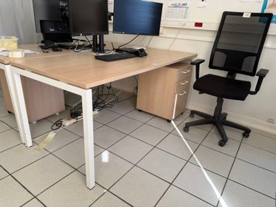 a desk with two computer monitors on it and a chair