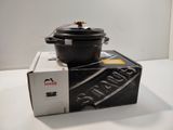 a black pot sitting on top of a box on a table