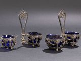three pieces of silver and blue glass on a gray surface