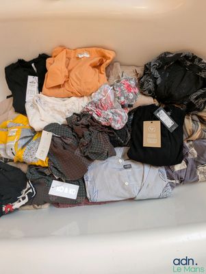 une image représentant une baignoire remplie d'une grande quantité de vêtements