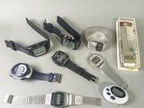 a lot of watches and other electronic devices on the table
