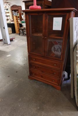un meuble en bois avec une porte en verre dans une pièce