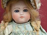 a close up of a doll with a hat on