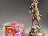 a statue of a woman holding a flower next to a box