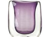 un vase en verre violet posé sur une surface blanche