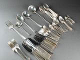 de nombreuses cuillères et fourchettes disposées sur la table