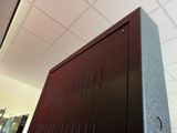 a brown cabinet with a black door in a room