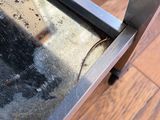a metal table with a glass top on a wooden floor