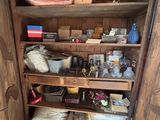 une étagère en bois sur laquelle sont posés de nombreux objets, dans une pièce