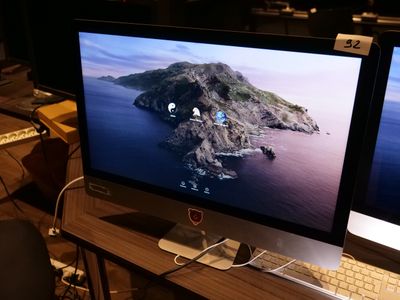 deux écrans d'ordinateur posés sur un bureau avec un clavier et une souris