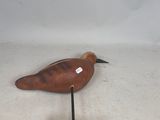 a small wooden bird sitting on top of a wooden base