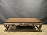 a wooden coffee table with ornate carvings on the top