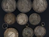 six types différents de pièces d'argent sur une surface noire