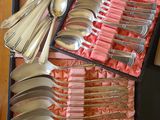 de nombreuses cuillères et cuillères-cuillères dans une boîte posée sur une table