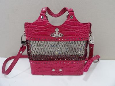 un sac à main rose et argenté posé sur une table blanche, muni d'une bandoulière rose