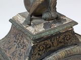 a clock with a statue of a man on top of it
