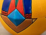 a yellow vase with a colorful design on it