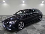 a black mercedes cla parked in a garage with a checkered floor
