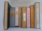 several old books are stacked on top of each other on a shelf