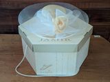 a white box with a flower in it on a table