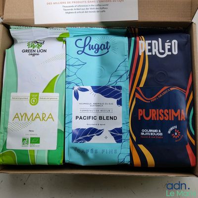 three bags of coffee in a box on a table