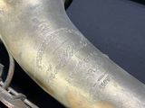 an old silver saxophone sitting on top of a black table