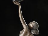 bronze statue of a woman holding a bird in her hand