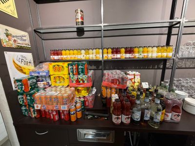 de nombreuses bouteilles et canettes de boissons sur une étagère