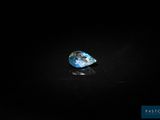 a blue diamond on a black surface in the dark