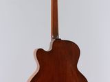 an acoustic guitar on a stand against a white background