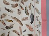 a scarf with feathers on it on a table