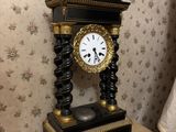 a black and gold clock sitting on a table next to a radiator