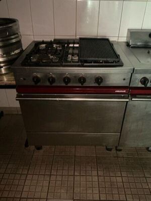 a kitchen with a stove, oven, and a pot on the counter