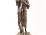 an antique bronze statue of a woman holding a bird on a base