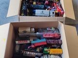 une boîte en carton remplie de petits trains et d'autres jouets