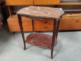 une petite table avec un plateau en marbre dans une pièce