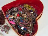 a red box filled with lots of jewelry on a table