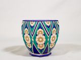 un vase bleu avec des fleurs sur un fond blanc