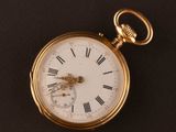 a gold pocket watch with roman numerals on it