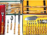 many different types of knives and spoons in a case