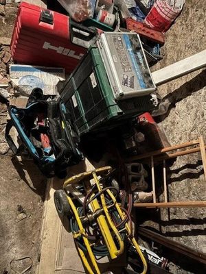 a pile of junk on the ground next to a pile of tools
