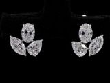 une paire de boucles d'oreilles en diamant posées sur du velours noir, sur fond noir